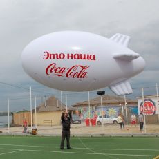 Фото надувного белого дирижабля с надписью: "Это наша CocaCola"